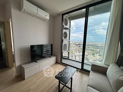Modern living room with balcony and city view, featuring sleek furniture and air conditioning.
