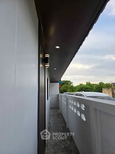 Modern exterior corridor with sleek design and ambient lighting, offering a serene outdoor view.