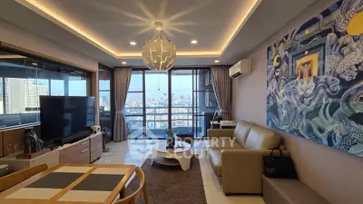 Modern living room with city view, stylish decor, and open layout in high-rise apartment.