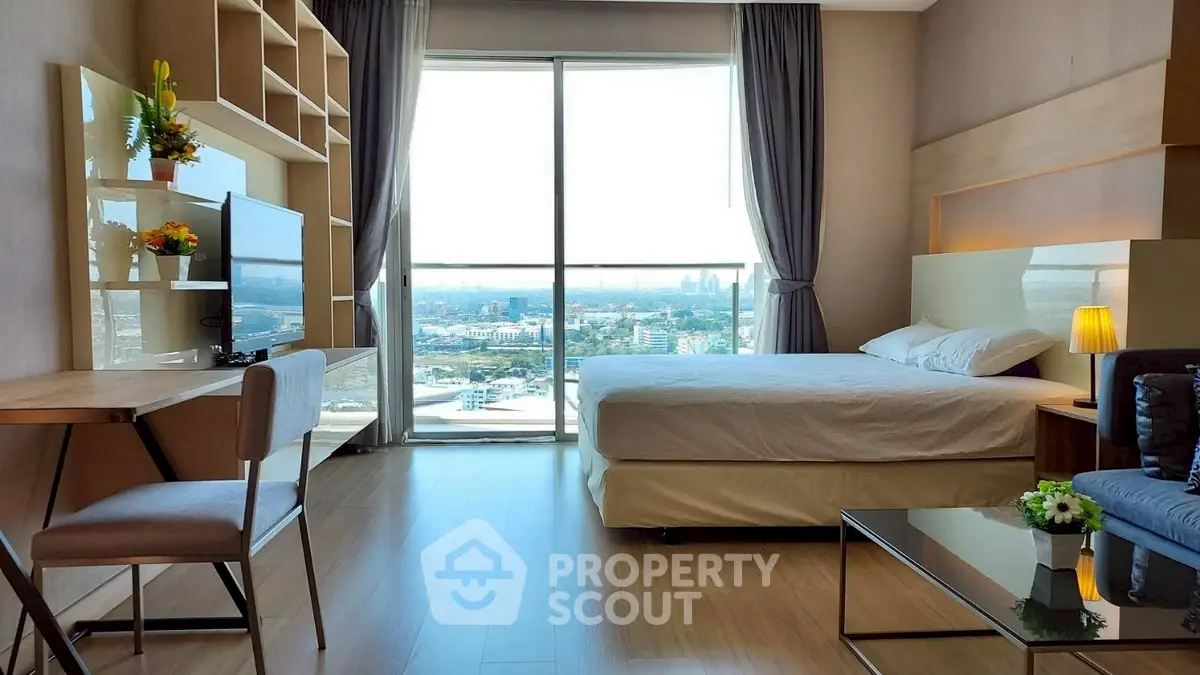 Modern bedroom with stunning city view, featuring elegant decor and natural light.