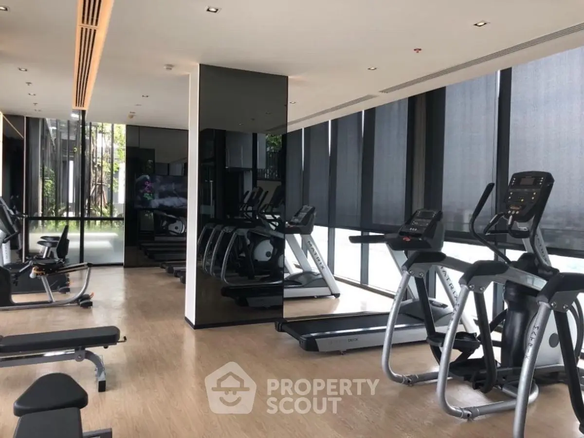 Modern gym with state-of-the-art equipment and large windows for natural light.