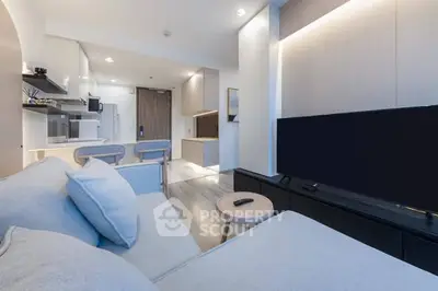 Modern living room with open kitchen layout and sleek furnishings