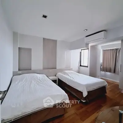Spacious bedroom with twin beds and modern air conditioning unit