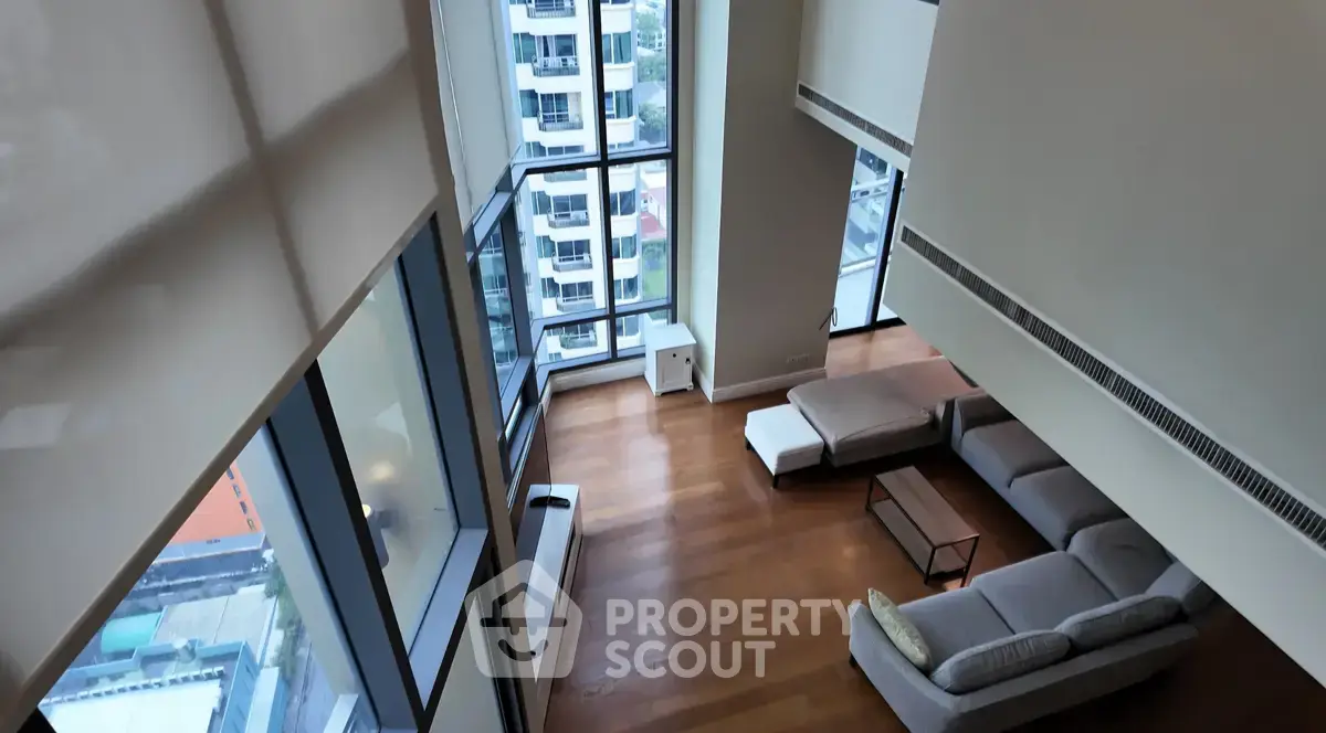Spacious modern living room with floor-to-ceiling windows and city view