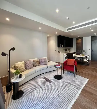 Modern living room with stylish furniture and open kitchen layout in a contemporary apartment.