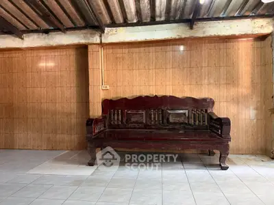 Rustic wooden bench in a tiled room with exposed ceiling beams, perfect for cozy living spaces.