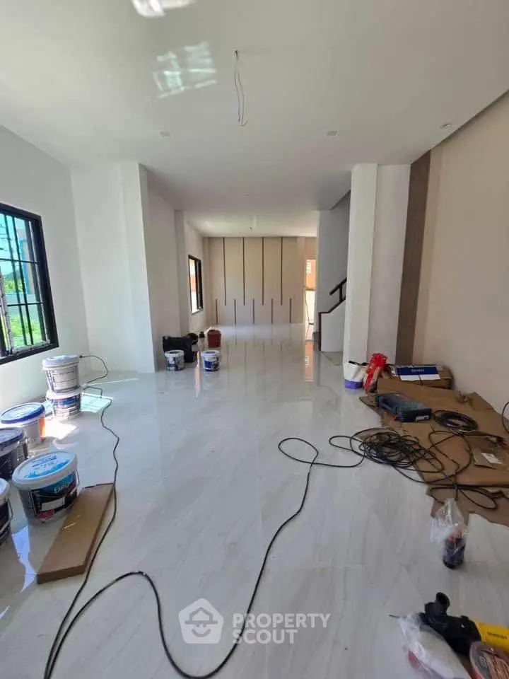 Spacious modern living room under renovation with glossy tile flooring and large windows