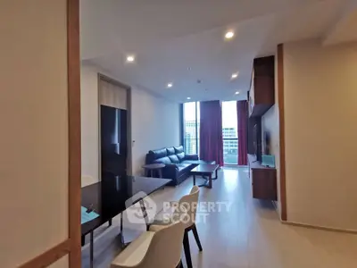 Modern living room with sleek furniture and large window offering city view