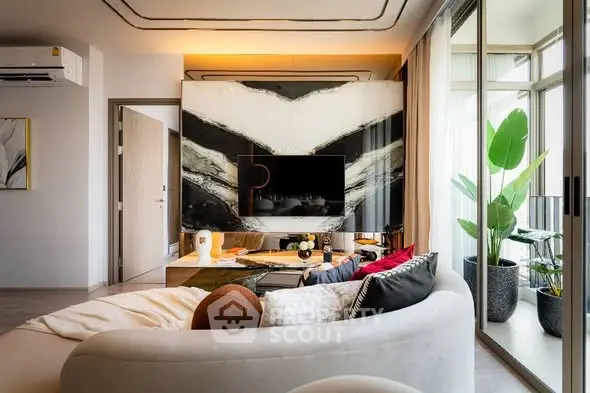 Modern living room with stylish decor and large windows opening to a balcony.