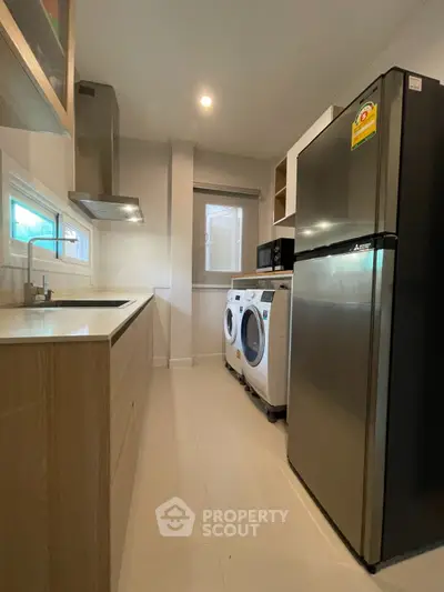 Modern kitchen with stainless steel appliances and washing machine
