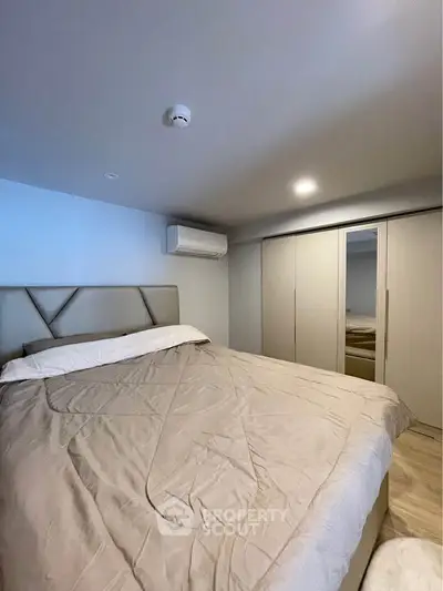 Modern bedroom with cozy bed and sleek wardrobe, featuring air conditioning for ultimate comfort.