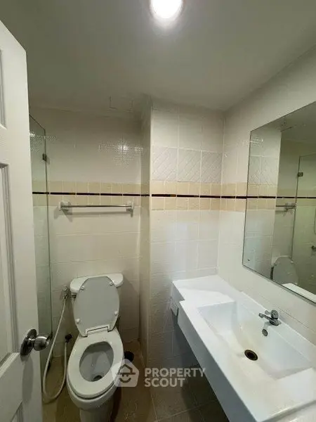 Compact bathroom with modern fixtures and neutral tiles