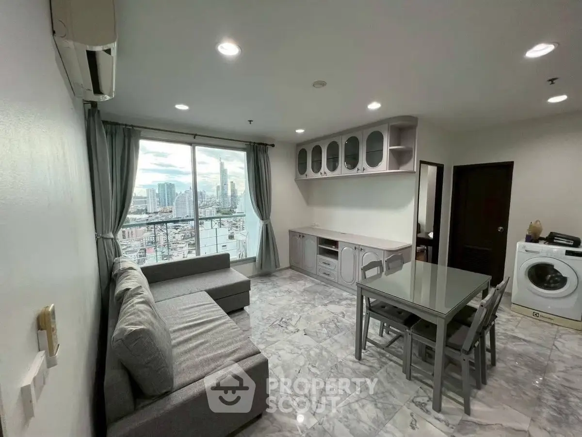 Modern living room with city view, featuring sleek furniture and marble flooring in a high-rise apartment.