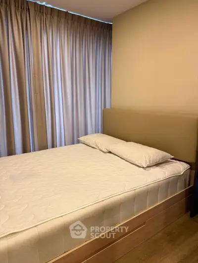 Cozy bedroom with modern design and natural light from large windows, featuring a comfortable bed and elegant curtains.