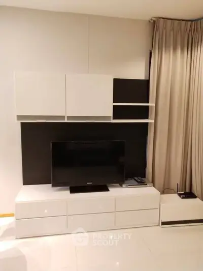 Modern living room with sleek white TV cabinet and elegant curtains
