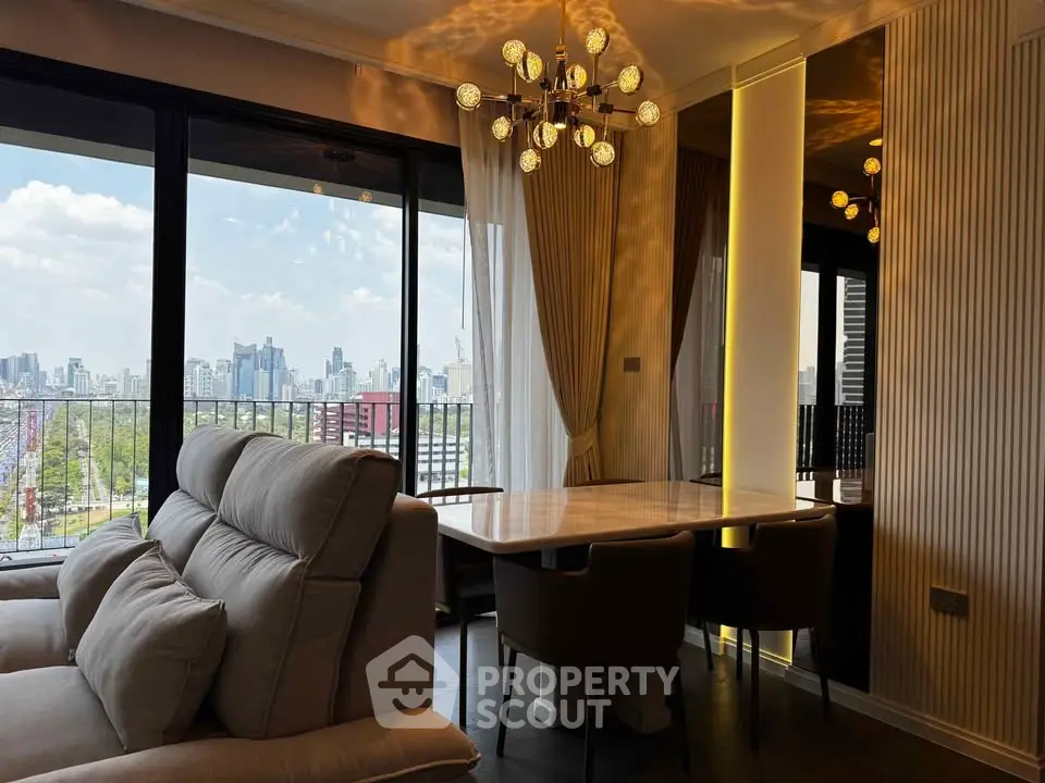 Luxurious living room with city view, elegant chandelier, and modern furniture in high-rise apartment.