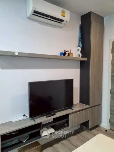 Modern living room with sleek TV unit and air conditioning, perfect for cozy entertainment.