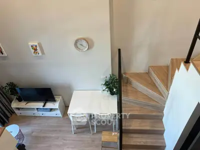 Modern duplex living room with stylish staircase and cozy dining area