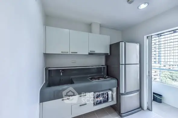 Modern kitchen with sleek design and stainless steel appliances in a bright apartment.