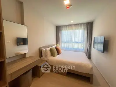 Modern bedroom with cozy bed, stylish decor, and natural light from large window.