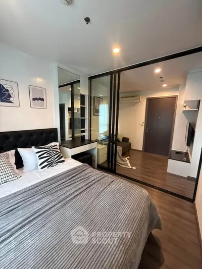 Modern bedroom with stylish decor and sliding glass doors in a contemporary apartment.