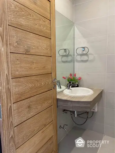 Modern bathroom with wooden door and sleek sink design