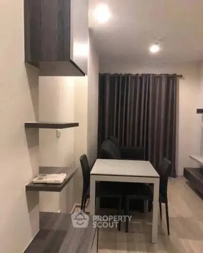 Modern dining area with sleek furniture and ambient lighting in a cozy apartment setting.