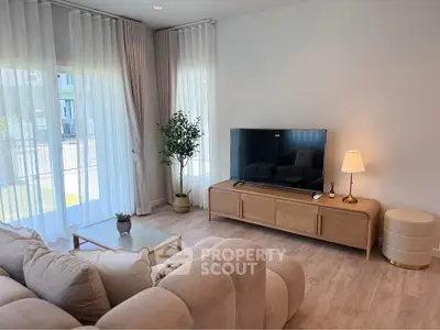 Elegant living room with modern decor, large windows, and cozy seating area, perfect for relaxation.