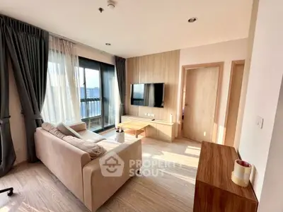 Modern living room with large windows and stylish furniture in a high-rise apartment.