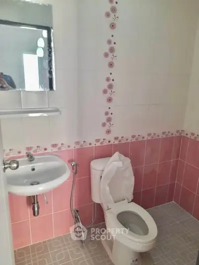 Charming bathroom with pink tile accents and modern fixtures, perfect for a cozy home.