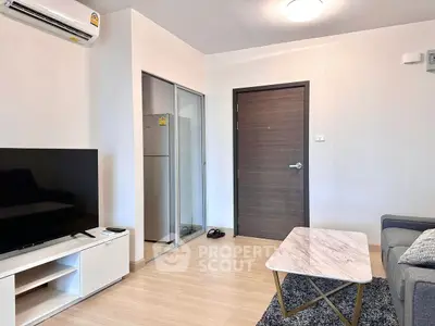 Modern living room with sleek furniture and stylish decor, featuring a TV and air conditioning unit.
