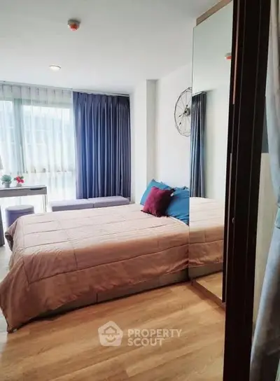 Cozy bedroom with modern decor and large window for natural light.