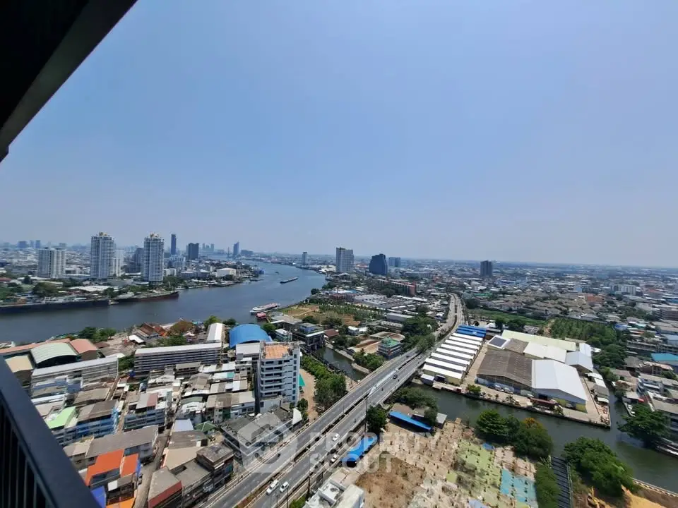Stunning panoramic cityscape view from high-rise balcony overlooking river and skyline.
