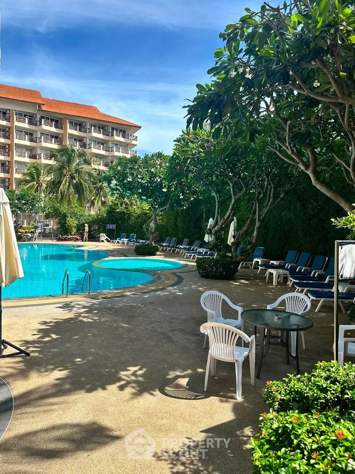 Luxurious poolside area with lush greenery and modern amenities in a resort-style residential complex.