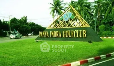Entrance to Panya Indra Golf Club with lush greenery and palm trees.