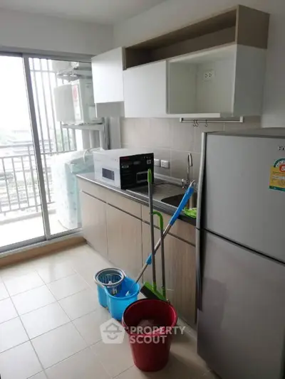 Modern kitchen with balcony view, featuring sleek cabinetry and appliances.