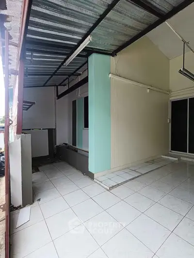 Spacious covered patio with tiled flooring and modern design.