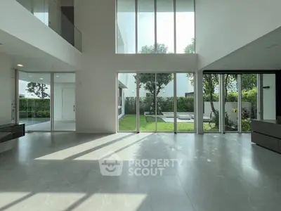 Spacious modern living room with large windows and garden view, perfect for natural light lovers.