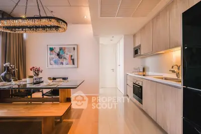 Modern kitchen with open layout and stylish dining area featuring elegant lighting and contemporary decor.