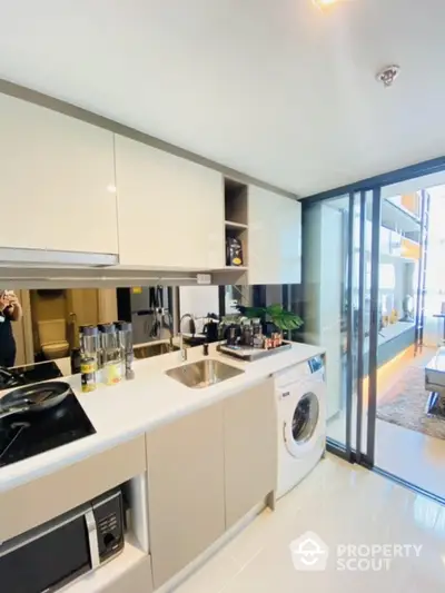 Modern kitchen with sleek appliances and washing machine in stylish apartment