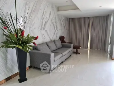 Modern living room with elegant marble walls and stylish gray sofa