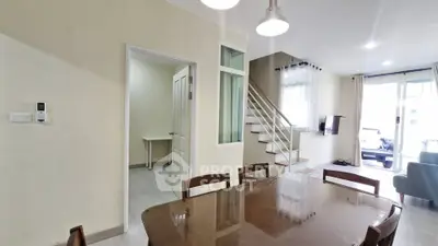 Spacious modern living room with dining area and staircase in a bright, open-concept home.