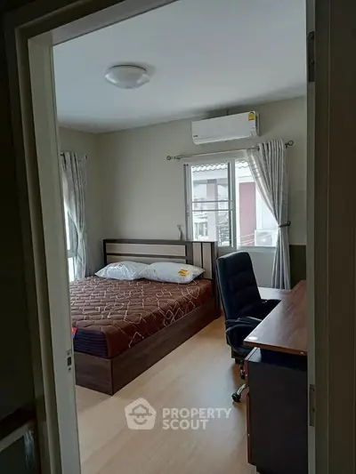 Cozy bedroom with modern furniture and natural light, perfect for relaxation and productivity.