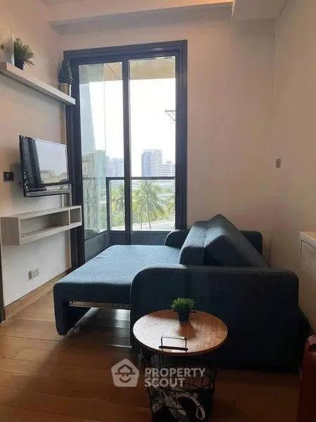 Cozy living room with modern sofa and TV, featuring a stunning city view through large windows.
