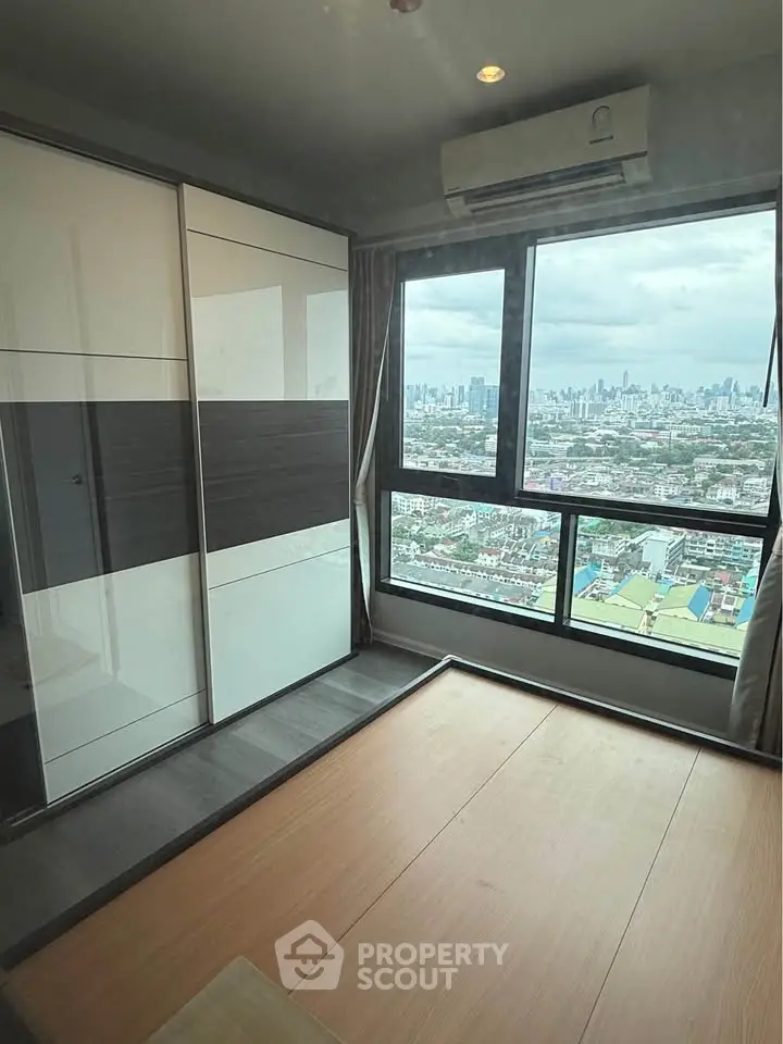 Modern bedroom with panoramic city view and sleek wardrobe design.