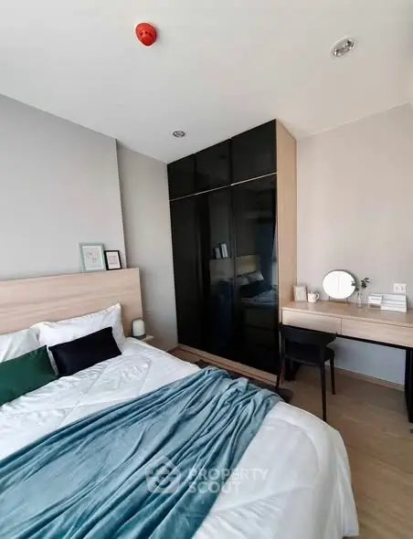 Modern bedroom with sleek wardrobe and cozy decor in a stylish apartment.