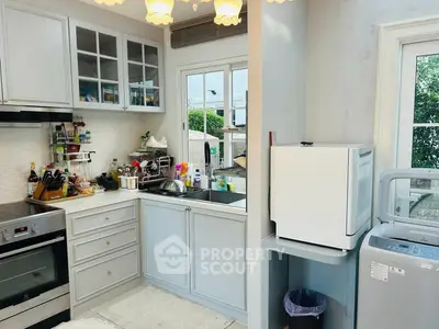 Charming kitchen with modern appliances and ample natural light, perfect for culinary enthusiasts.
