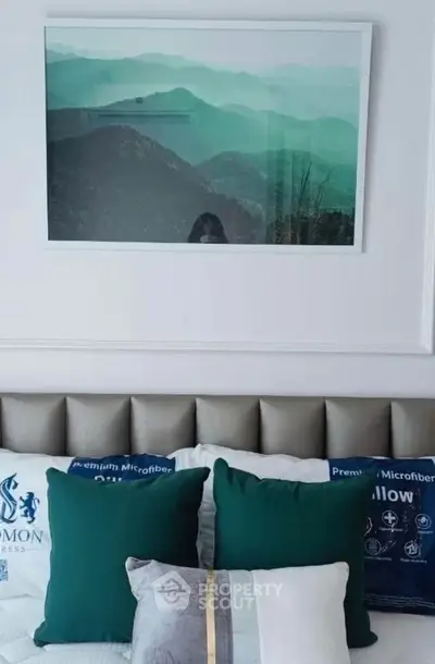 Stylish bedroom with elegant decor and mountain landscape artwork above bed
