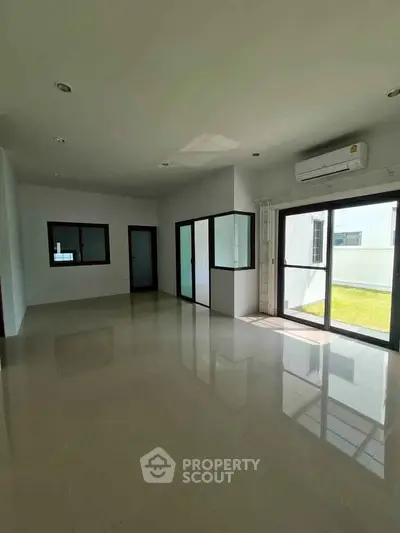Spacious sunlit room with large windows and air conditioning, perfect for modern living.