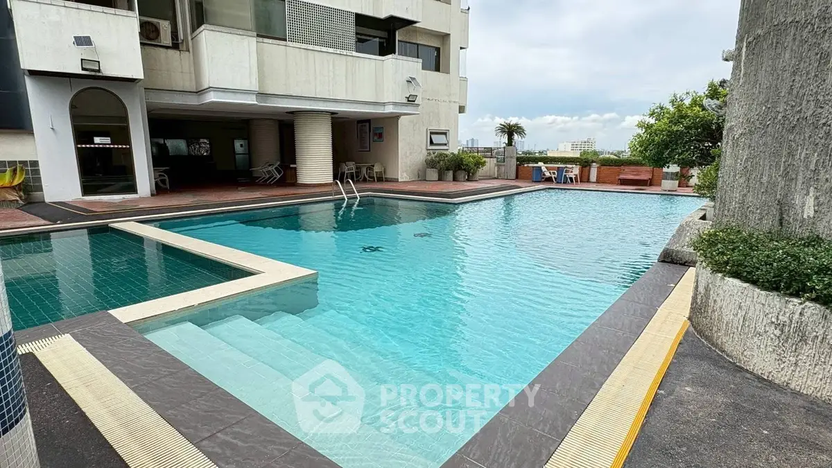Luxurious residential building with a stunning outdoor pool and spacious deck area.